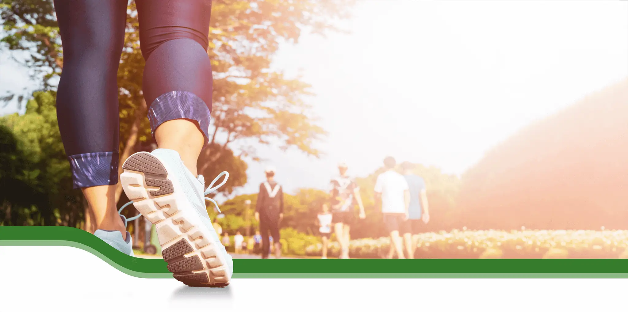 The feet of a woman as she steps towards a group of people ahead of her.